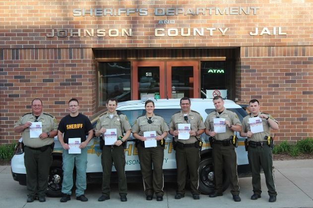 Officers lined up in front of the johnson county sheriff building